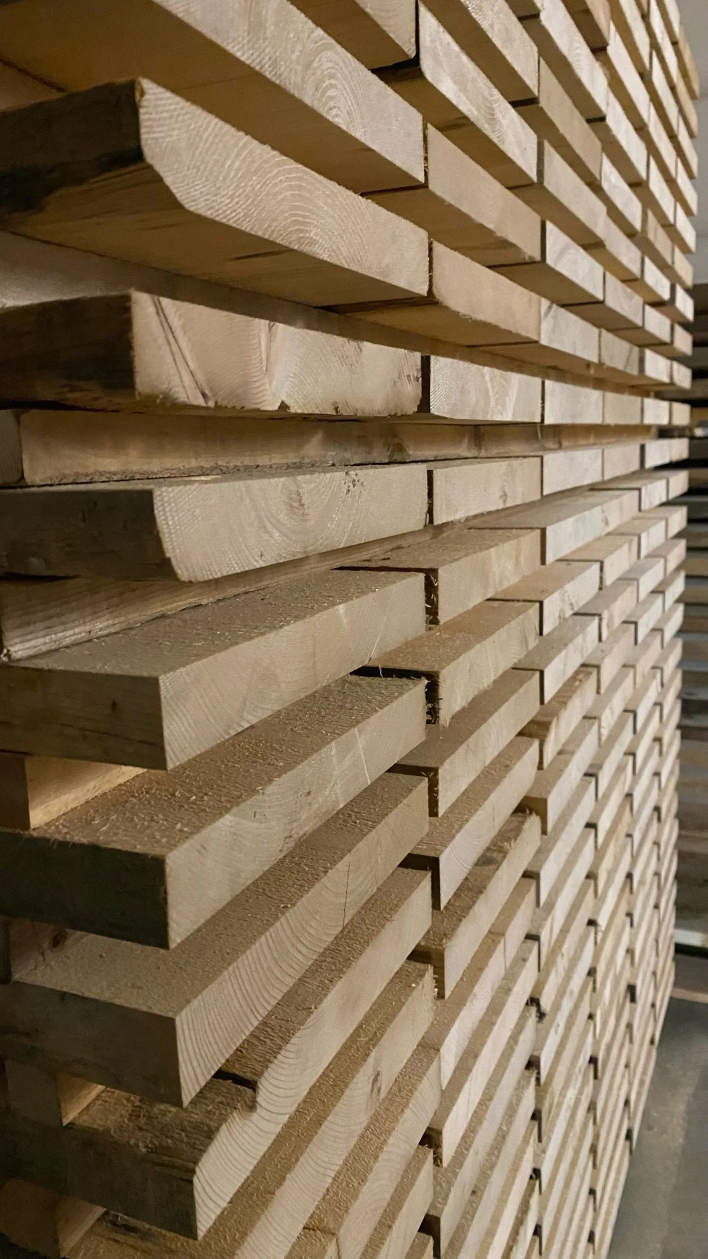 Stacked, kiln-dried SRL lumber boards on a processing rack.